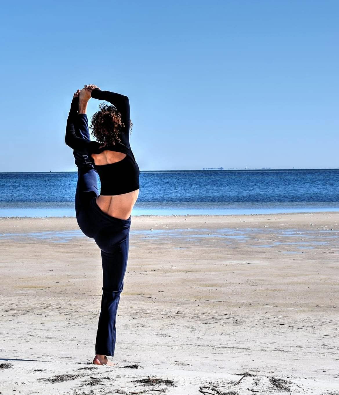 Alora practicing yoga on the beach