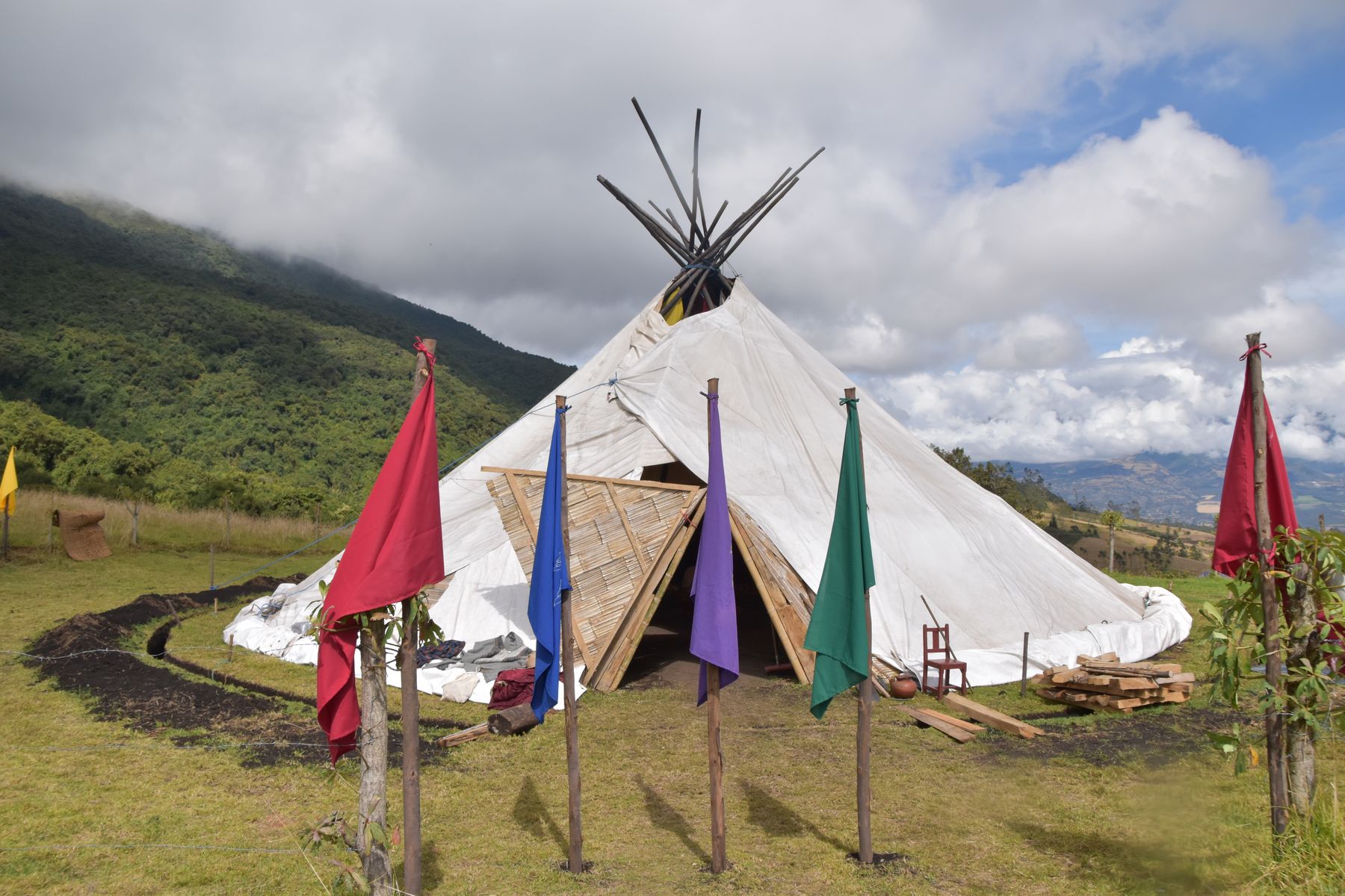 A ceremonial tipi with four colored prayer flags on the Andean mountainside in Ecuador, prepared for a Vision Quest
